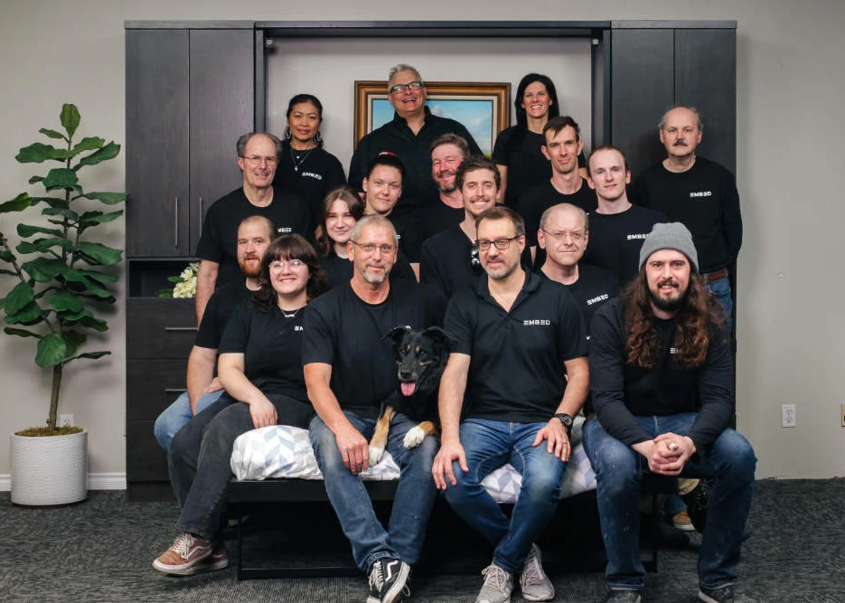 Embed Home Products team (16 people) and a dog sitting on a Murphy Bed